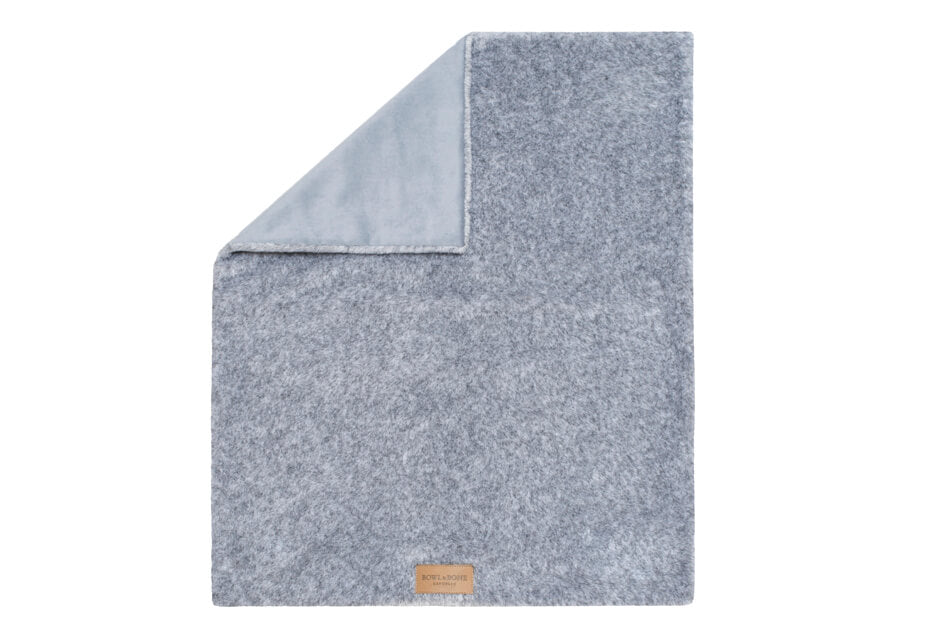 A Bowlandbone dog blanket folded on top of a white surface.