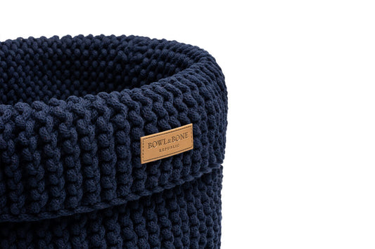 A blue knitted Bowlandbone basket for dog toys COTTON navy with a leather label.