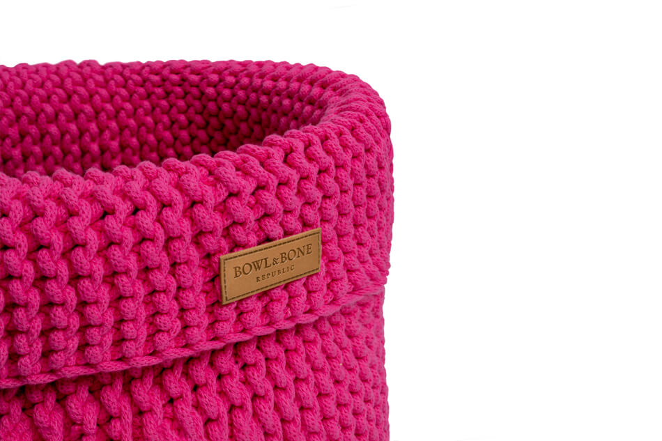 A Bowlandbone pink knitted basket for dog toys COTTON on a white background.