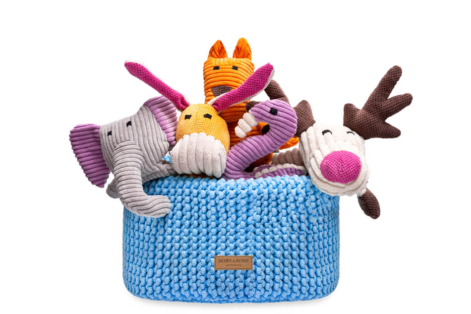 A Bowlandbone DOUBLE blue basket for dog toys filled with stuffed animals.