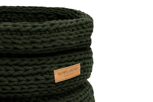 A Bowlandbone knitted basket for dog toys RING green with a leather label.