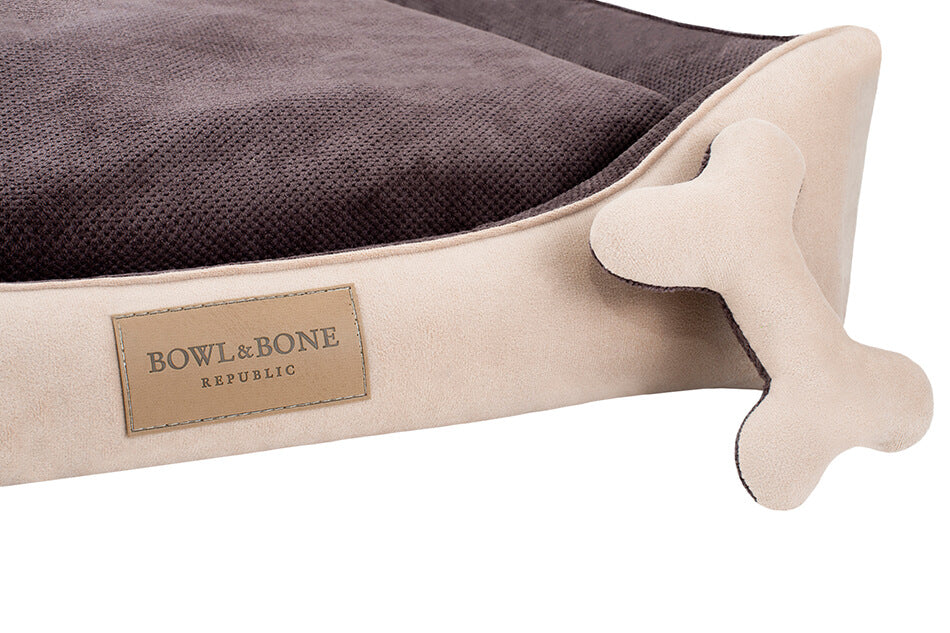 A CLASSIC Bowl&Bone Republic dog bed brown with a bone on it.