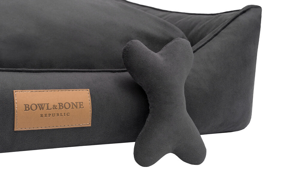 A Bowl&Bone Republic dog bed in CLASSIC graphite with a bone on it.