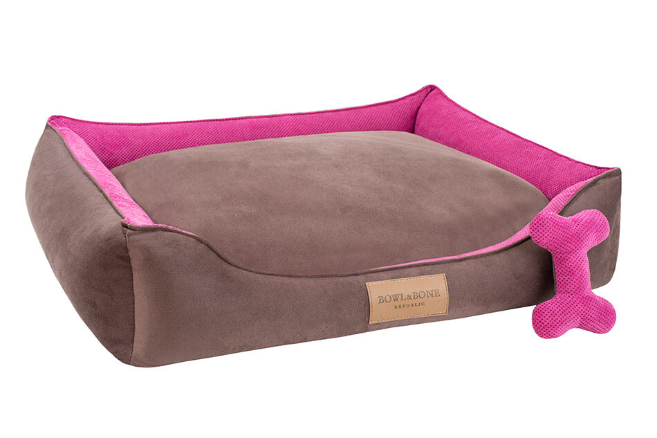 A pink Bowlandbone Republic dog bed with a pink bone.