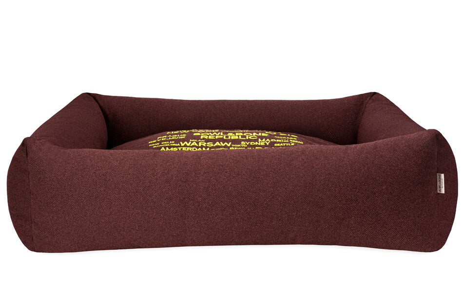 A COSMOPOLITAN Bord&Bone Republic dog bed with yellow letters on it.