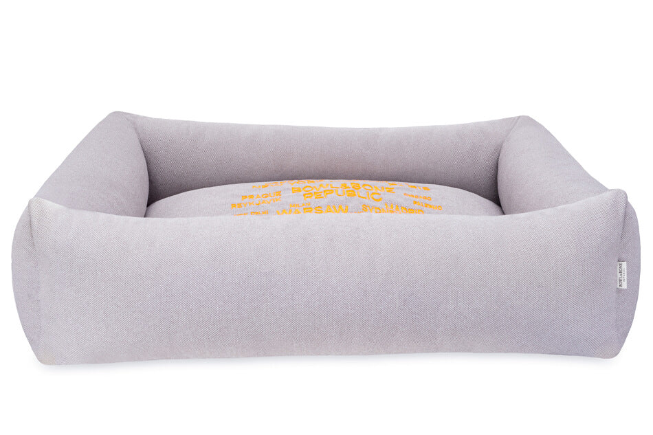 A grey COSMOPOLITAN platinum dog bed with a yellow embroidered design by Bowl&Bone Republic.