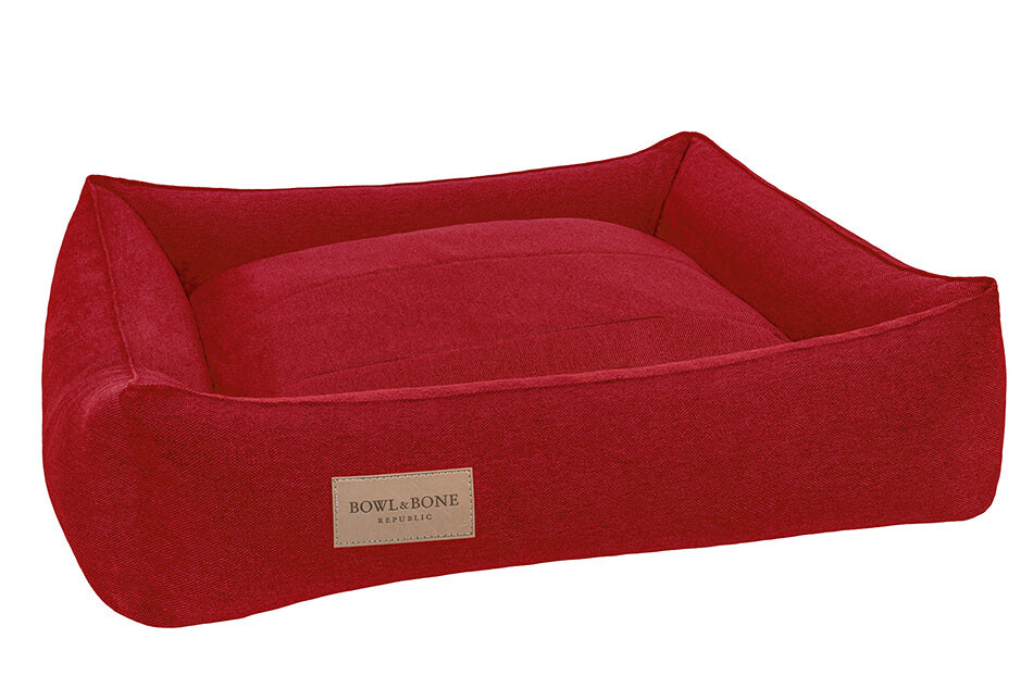 A dog bed URBAN red with a Bowl&Bone Republic label on it.