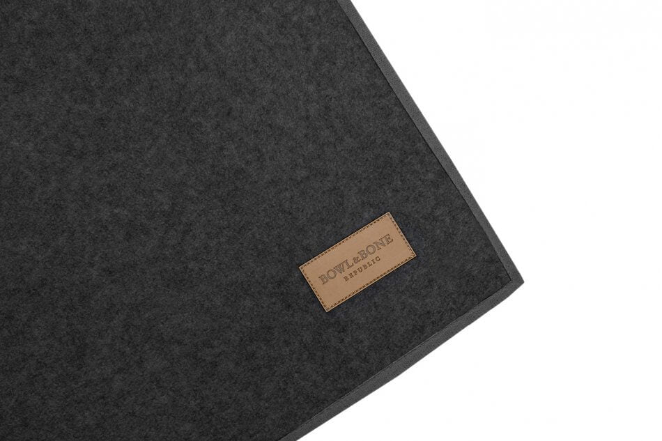 A black laptop sleeve with a brown label by Bowlandbone.