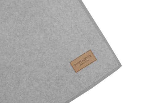 A Zen grey dog blanket made by Bowl&Bone Republic with a brown label on it.
