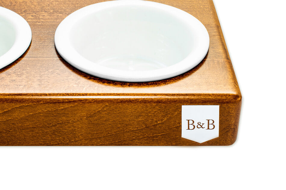 A wooden tray with two Bowlandbone Republic dog bowl DUO CERAMIC amber bowls on it.