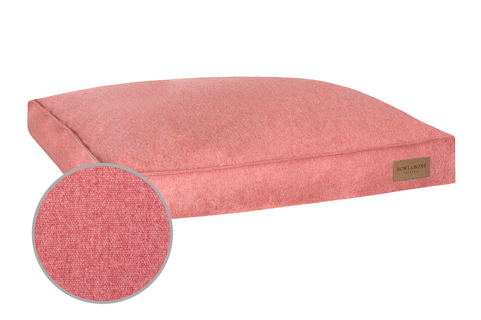 A Bowl&Bone Republic dog cushion bed LOFT coral with a round shape.