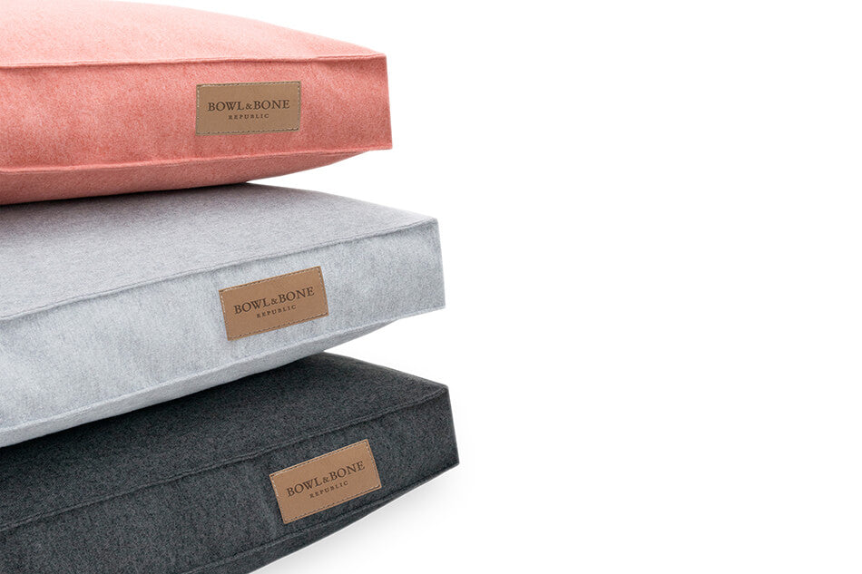 A stack of LOFT grey pillows by Bowl&Bone Republic for dogs.
