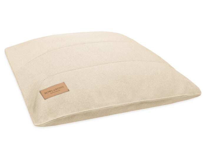 A beige dog cushion bed URBAN from Bowlandbone, featuring a brown label.