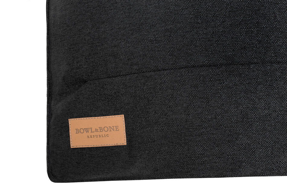 A black dog cushion bed URBAN graphite with a tan label from Bowlandbone Republic.