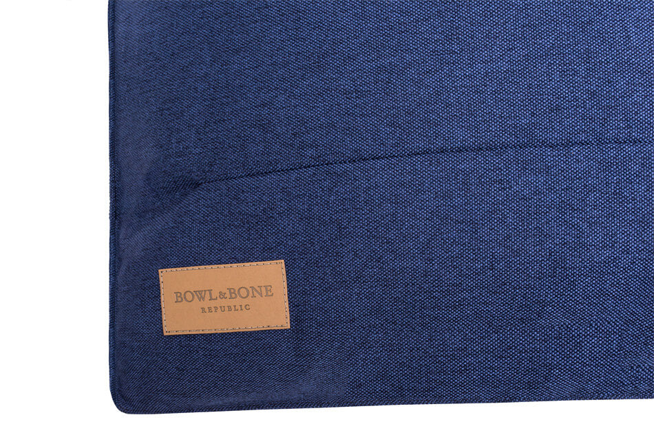 A dog cushion bed URBAN navy with a Bowl&Bone Republic label on it.