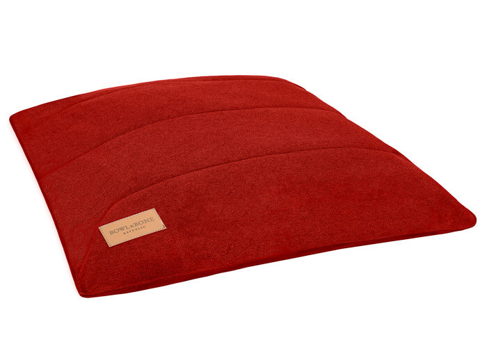 A URBAN red dog cushion bed by Bowl&Bone Republic with a brown label on it.