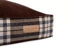 A Bowl&Bone Republic dog cushion bed in SCOTT brown with a plaid pattern on it.