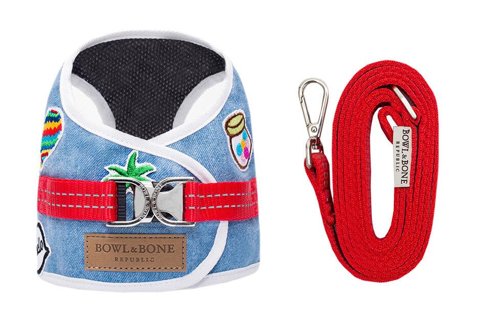 A Bowl&Bone Republic dog harness in DENIM blue with a leash attached.
