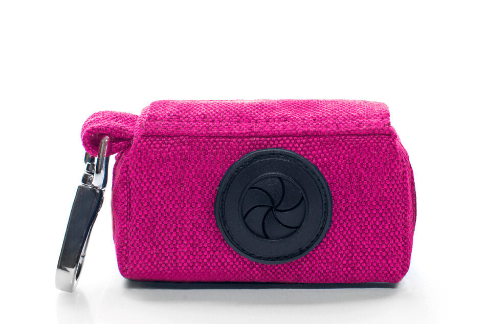 A Bowlandbone Republic dog waste bag holder MINI pink with a key ring attached to it.